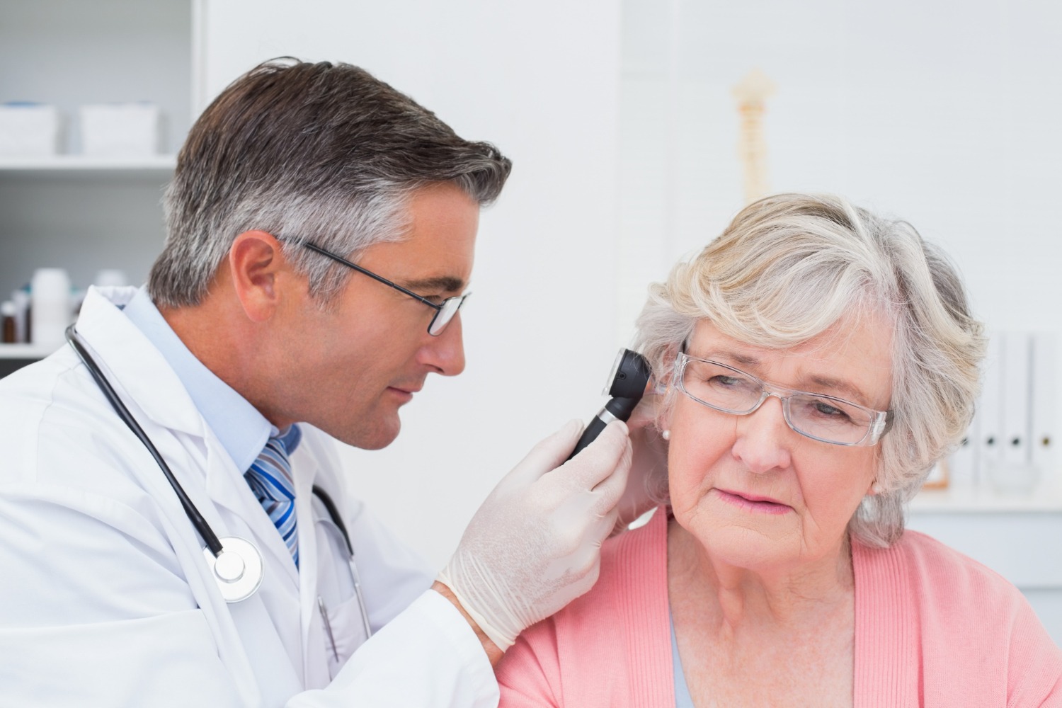 Audiologist performing microsuction ear wax removal on a patient